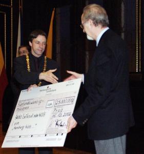 FOTO - ...který předal pražskému primátorovi symbolický šek na 25 milionů korun