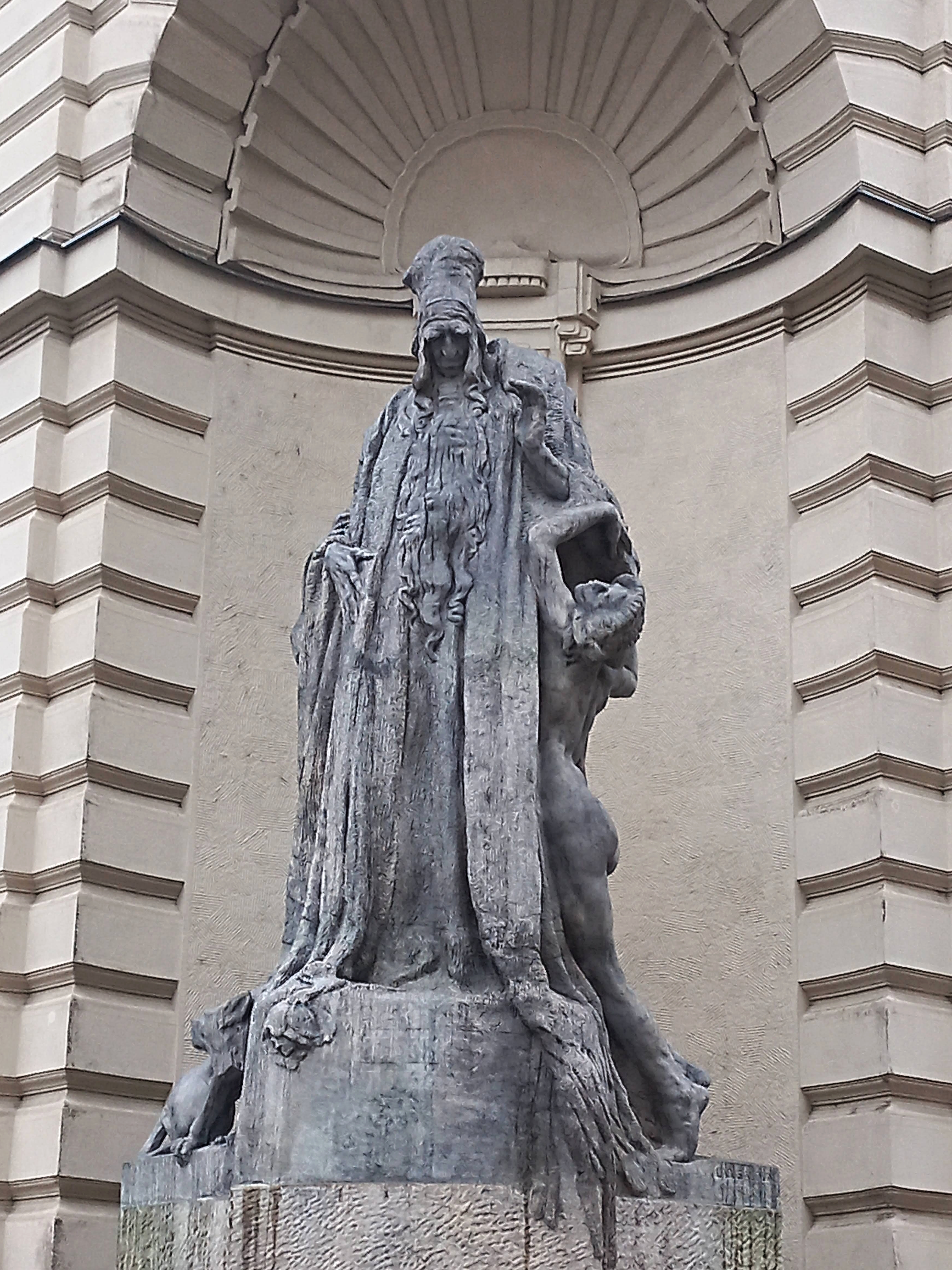 Kamenný Rabbi Löw v nadživotní velikosti stojí na nároží Nové radnice.